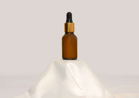 Lotion mockup on a white silk fabric podium. Gentle skincare concept. close-up.