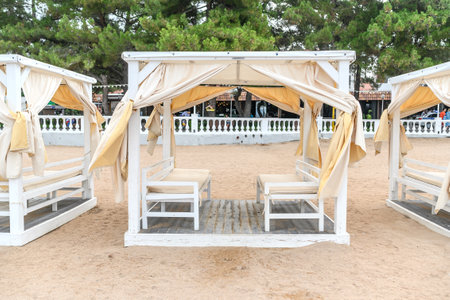 White sun loungers on the coast of the sea and the beach in summer. Rest and relaxation on vacation.