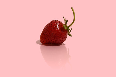 Strawberry red with reflection on a pink background. Fresh tasty berry. close-up.
