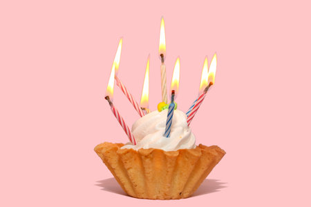 Cake basket sweet tasty dessert. Cream dough. Candles for the holiday. On a pink background.