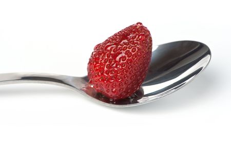 Juicy strawberry with drops on a metal spoonの写真素材