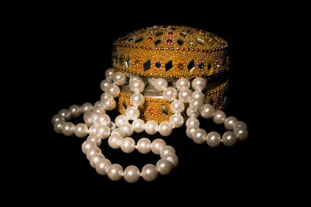 Pearl beads in the slightly opened casket one the black backgroundの写真素材