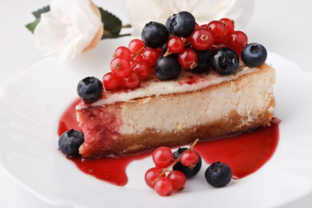Portion of cheese cake New-York with berries and sauceの写真素材
