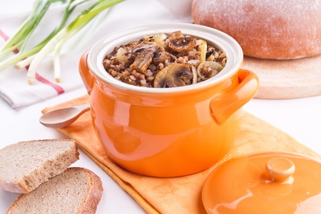 Buckwheat with mushrooms in an orange potの写真素材