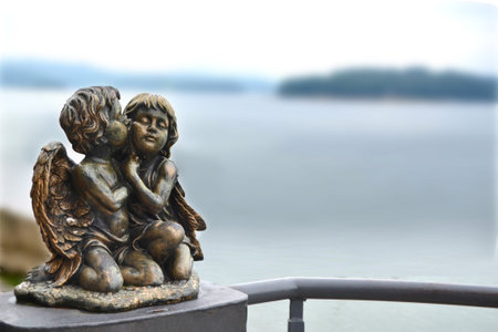 two angels kissing sculpture on the wall. High quality photo