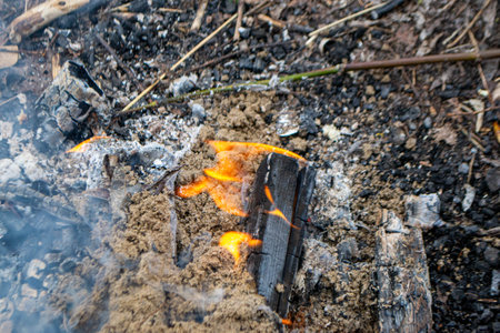 A fire burns in a campfire with a red fire in the background. High quality photoの写真素材
