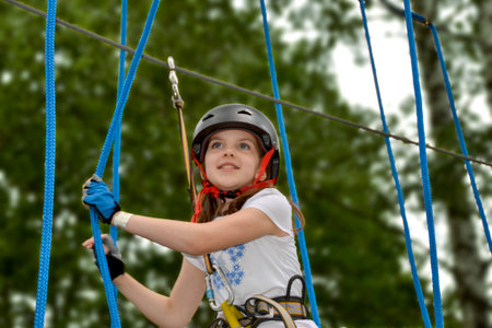 adventure climbing high wire park - people on course in mountain helmet and safety equipment. High quality photoの写真素材
