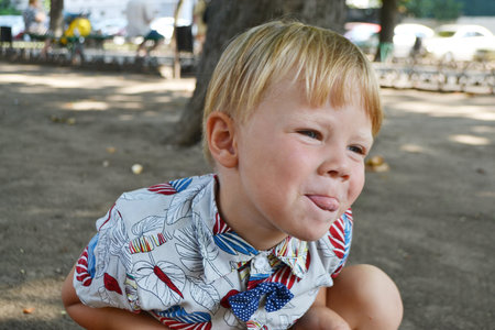 Blond boy 4 years old playing on a children playground and has fun. High quality photo.