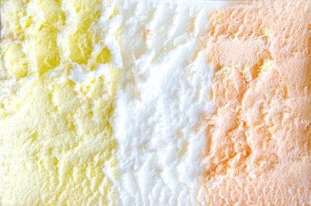 texture of yellow white and green ice cream like background, close up. Strawberry ice cream texture close up. Top view. Pink fruit ice cream background with small pieces of berries. High quality photoの写真素材