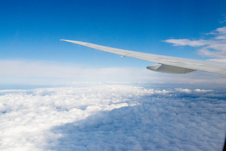 White passenger airplane flying in the sky amazing clouds in the background - Travel by air...