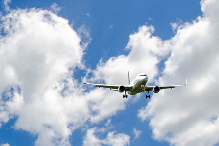 White passenger airplane flying in the sky amazing clouds in the background - Travel by air...