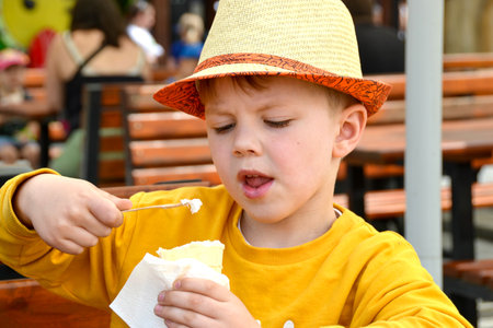 Happy child, boy eating ice cream, enjoying summer, playing. High quality photoの写真素材