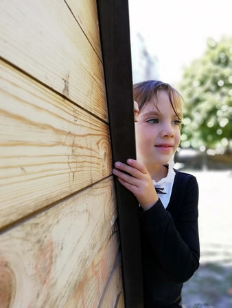 Beautiful little girl, studio portrait on a wooden background. The concept of children's emotions, style and fashion. Black and white photo. High quality photoの写真素材
