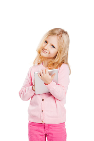 Happy little girl using tablet computer. Isolated on whiteの写真素材