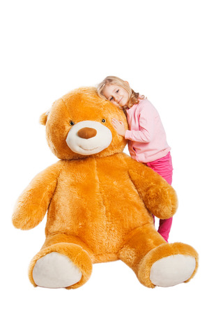 Little smiling girl with big huge Teddy bear.の写真素材