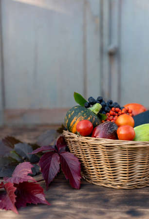 Composition of fresh vegetables in a basket on a wooden background. Autumn harvest. Happy Thanksgiving.の写真素材