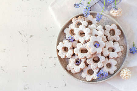 Italian traditional cookies are canestrelli on a white background with flowers. Homemade pastries....