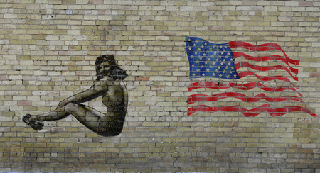 Old yellow  bricks wall with graffiti girl and american  flagのeditorial素材