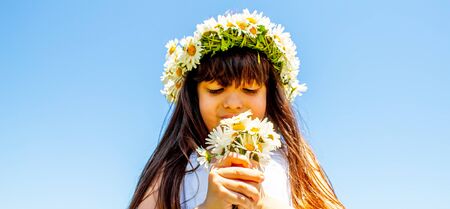 Girl with daisies in hands on the field. Selective focus.flowerの写真素材