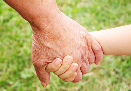 old man holding child's hands. selective focus.people