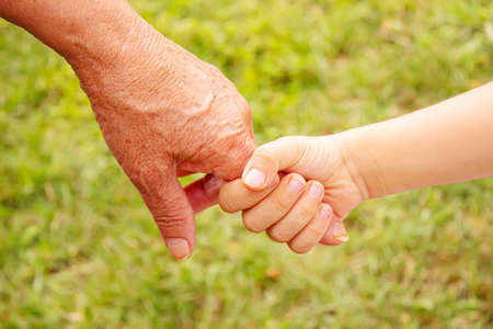 old man holding child's hands. selective focus.people