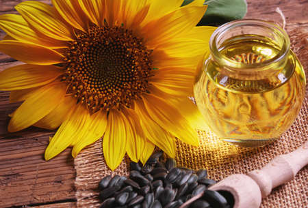 Sunflower seeds and oil bottle on old wooden background. Selective focus.natureの写真素材