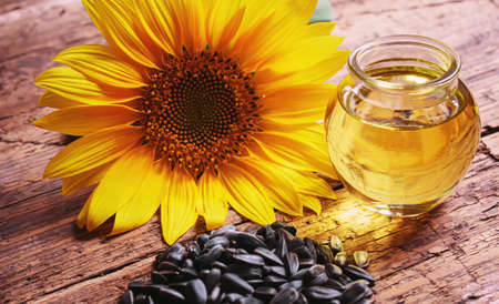 Sunflower seeds and oil bottle on old wooden background. Selective focus.natureの写真素材