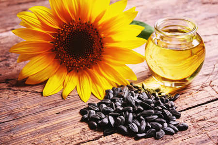 Sunflower seeds and oil bottle on old wooden background. Selective focus.natureの写真素材