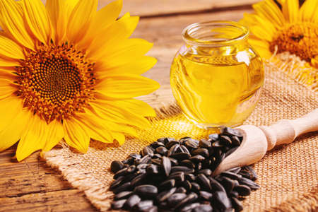 Sunflower seeds and oil bottle on old wooden background. Selective focus.natureの写真素材