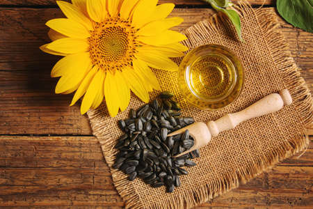 Sunflower seeds and oil bottle on old wooden background. Selective focus.natureの写真素材