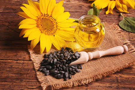 Sunflower seeds and oil bottle on old wooden background. Selective focus.natureの写真素材