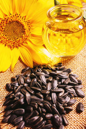 Sunflower seeds and oil bottle on old wooden background. Selective focus.natureの写真素材