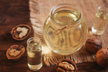 Walnut oil with nuts on a wooden background.selectiv focus.food