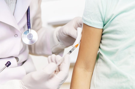 Vaccination of a child by a doctor in a hospital. Selective focus.medicalの写真素材