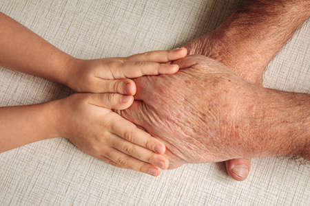 old man holding child's hands. selective focus peopleの写真素材