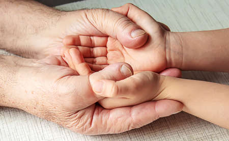 old man holding child's hands. selective focus peopleの写真素材