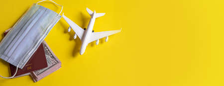 Travel preparation concept of airplane, money, passport, on yellow background. Selective focus.holidaysの写真素材