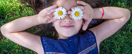 girl is holding chamomile flowers in her hands. Selective focus. nature.の写真素材