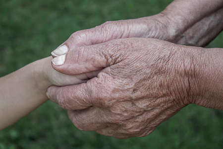 old man holding child's hands. selective focus peopleの写真素材