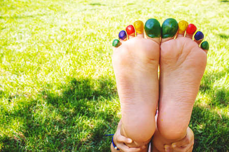 Children's feet with a pattern of paints smile on the green grass. Selective focus. nature.の写真素材