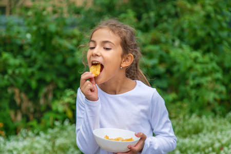 A child eats chips on the street. Selective focus.food