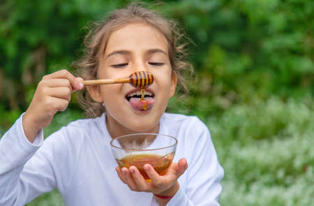 The child eats honey. Selective focus.foofの写真素材