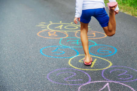 Child jumping classics on the pavement. Selective focus.natureの写真素材