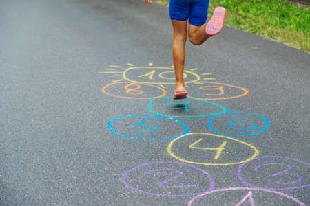 Child jumping classics on the pavement. Selective focus.natureの写真素材