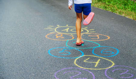 Child jumping classics on the pavement. Selective focus.natureの写真素材