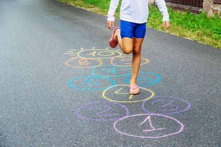 Child jumping classics on the pavement. Selective focus.natureの写真素材