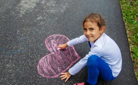 The child draws with chalk on the asphalt. Selective focus.natureの写真素材