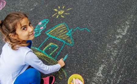 The child draws with chalk on the asphalt. Selective focus.natureの写真素材