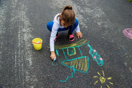 The child draws with chalk on the asphalt. Selective focus.natureの写真素材