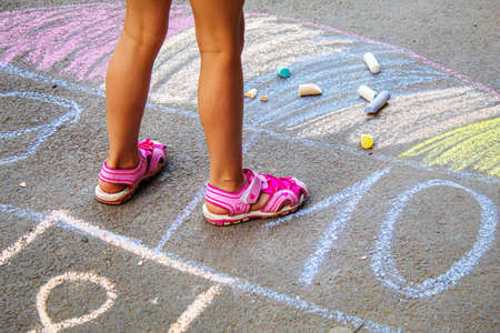 Child jumping classics on the pavement. Selective focus.childの写真素材